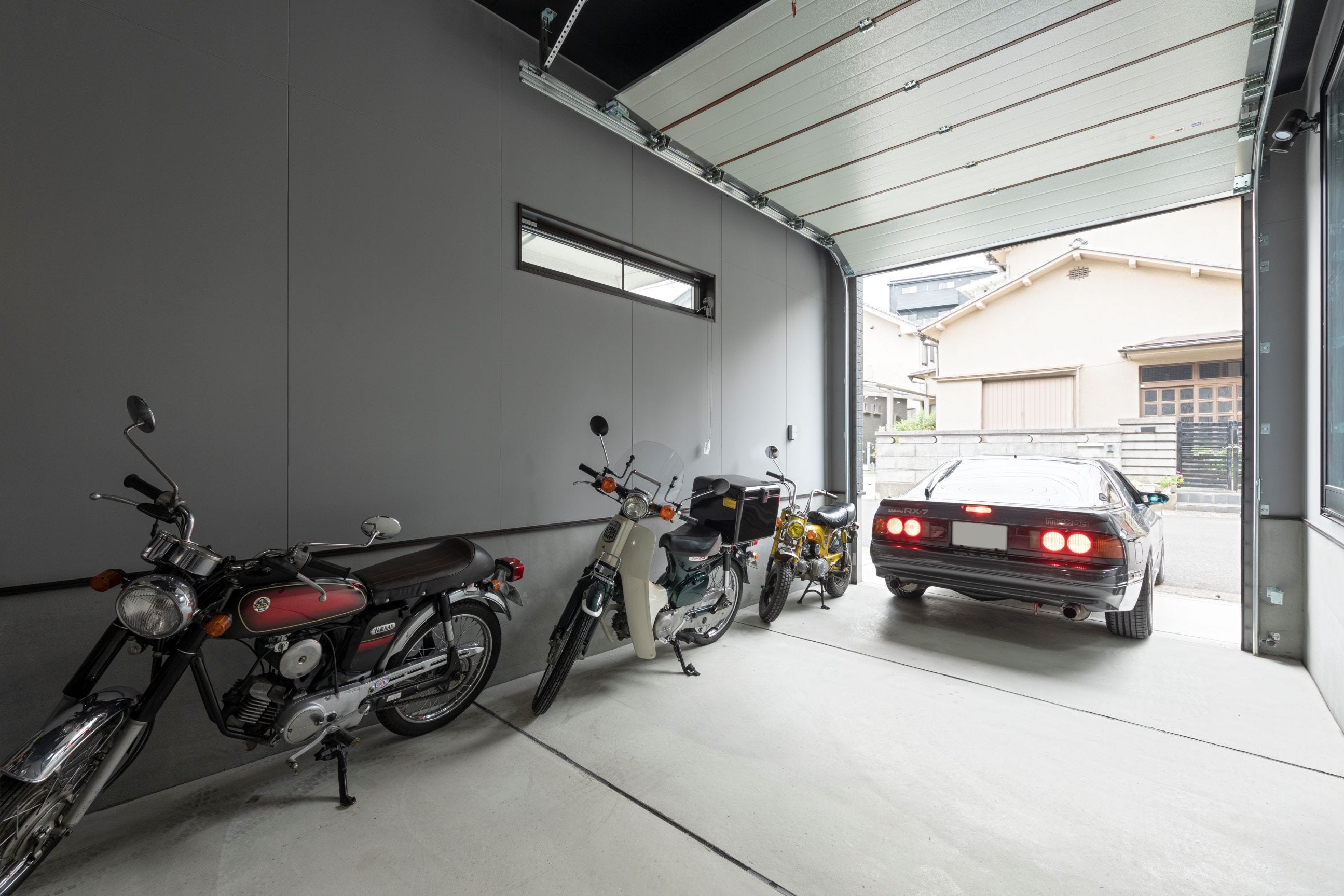 愛車は勿論、バイク2台を収めることのできる自慢のガレージ。
ちょっとした整備もガレージ内で行えます。
シャッター開閉はリモコン式なので、帰宅時も出発時もスムーズに出し入れ可能です。
