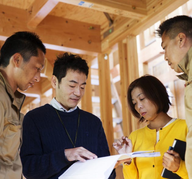 〇売ることを目的とした専任の営業マンはいらない
年間20棟以上受注しているハウスビルダーは、営業マンが営業受注してそれを設計工務に引き継ぐシステムの会社が一般的なのですが、吉田建設にはモデルハウスもなければ専属の営業マンもいません。最初の相談から建築士(設計担当)が行い、それ以後も建築士を中心にプランニング、設計、施工と進んでいきます。
どのように営業受注をしているかというと、私たちの主な受注の源は「紹介」です。OB施主さま、知人、協力業者などからの紹介受注が多くを占めています。その為に私たちは「紹介」を頂けるように、常に“満足度の高い家づり”“廻りからの信用・信頼”“密な人間関係”などを大切に仕事をしています。
吉田建設は“家を売る会社ではなく、家をつくる会社”だから“売ることを目的とした専任の営業マンはいらない”吉田建設のこだわりです。
〇ワンストップ責任施工体制
吉田建設の家づくりは、技術屋肌の社長・設計・インテリアコーディネーター・自社大工・協力業者といった技術職(建築士)と暮らしアドバイザー・融資FP担当・お客様サポートがそれぞれの立場から意見を出し合いお互いに協力しながら、ひとつのチームとしてお客様の夢のマイホームを、一棟一棟丁寧に心を込めてつくっていきます。その際、全てを取りまとめるのがチームリーダーです。
吉田建設は、「設計営業」「自社での設計と申請業務」「設計監理+大工監督」「自社大工による施工」など独自のシステムを構築しています。それは、直接建築に必要ないと思われる経費をできるだけ削減し建築コストを下げ、またできるだけ外注しないで社員の手で責任の持てる家づくりをしたいと考えているからです。
他のハウスビルダーとは違った技術者集団の「ワンストップ責任施工体制」は、吉田建設のこだわりの家づくりとなっています。
