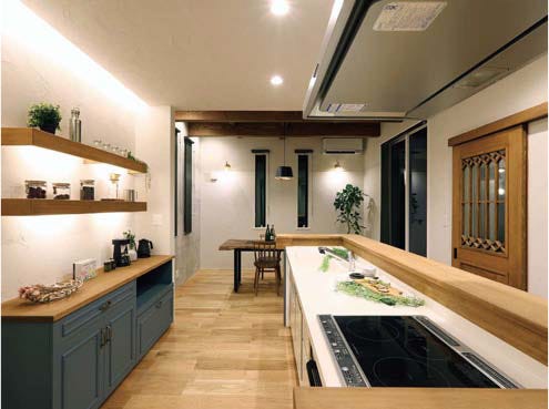 自社オリジナルの製作食器棚と上部のライン照明でアクセントをつけた、暖かみのあるキッチン。