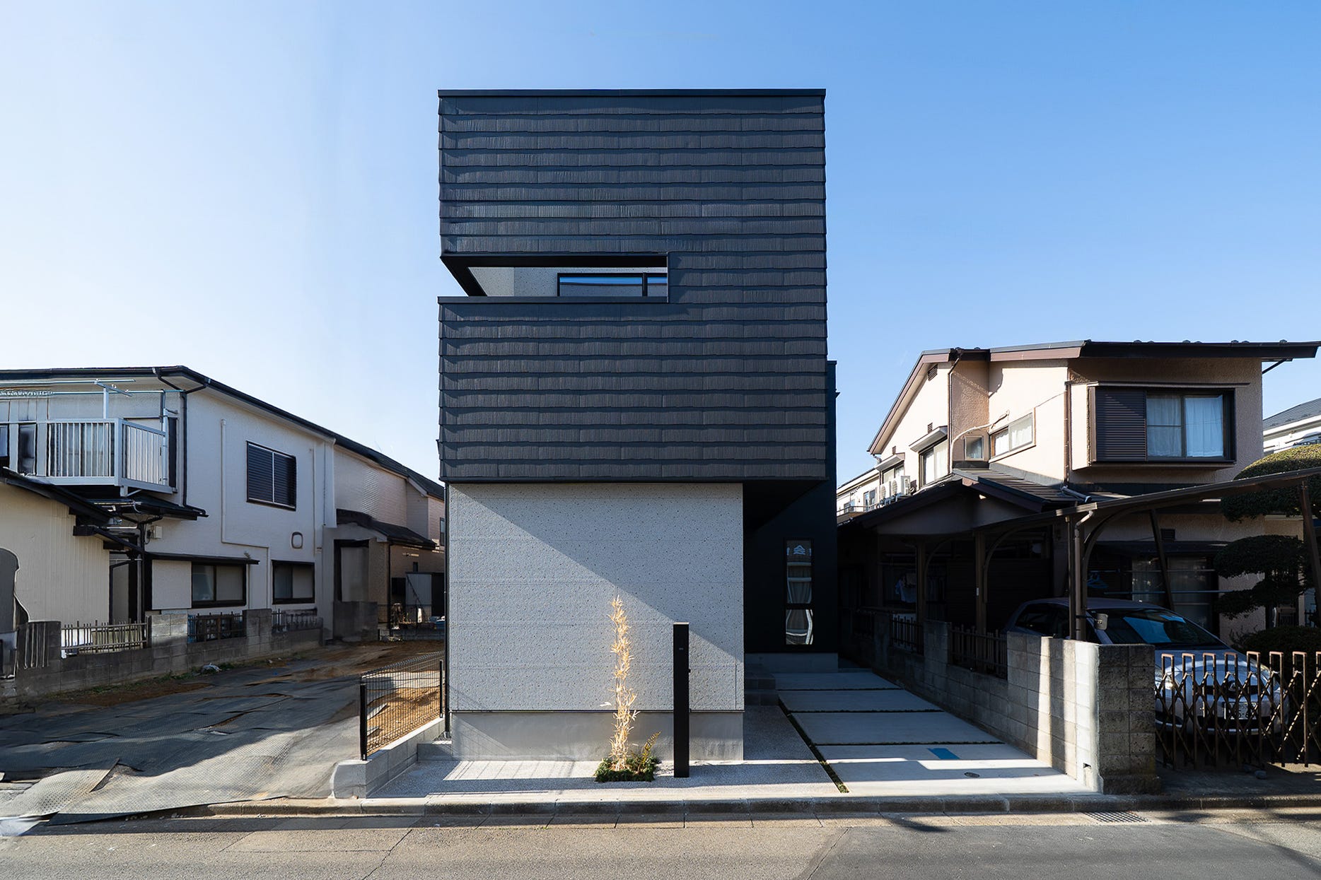 建築工房　櫓　素材と光が調和する家 (住宅ひしめく立地の中でも家族で居心地の良さを共有するべく、皆が集いたくなるような空間をより上に求め、明るさとプライバシーを両立したプランニングとしました。
また、リビングで寝ころんだ目線の先には木材を活かした現し天井、壁には大谷石と塗り壁を配しました。
ところどころに自然素材を設けることで日常的に多様な素材に触れ、温もりを感じることの出来る暮らしを目指しました。)