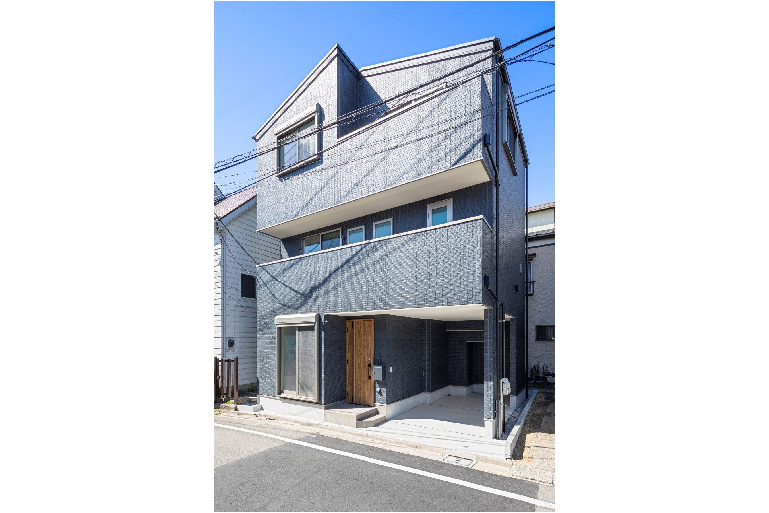 落ち着いたグレーの外壁が印象的な外観は、直線的で無駄のないフォルムが都会的な美しさを際立たせます。
玄関横にはインナーガレージを設け、雨の日でも快適に車への出入りが可能です。
限られた敷地を最大限に活かし、機能性とデザイン性を両立しました。