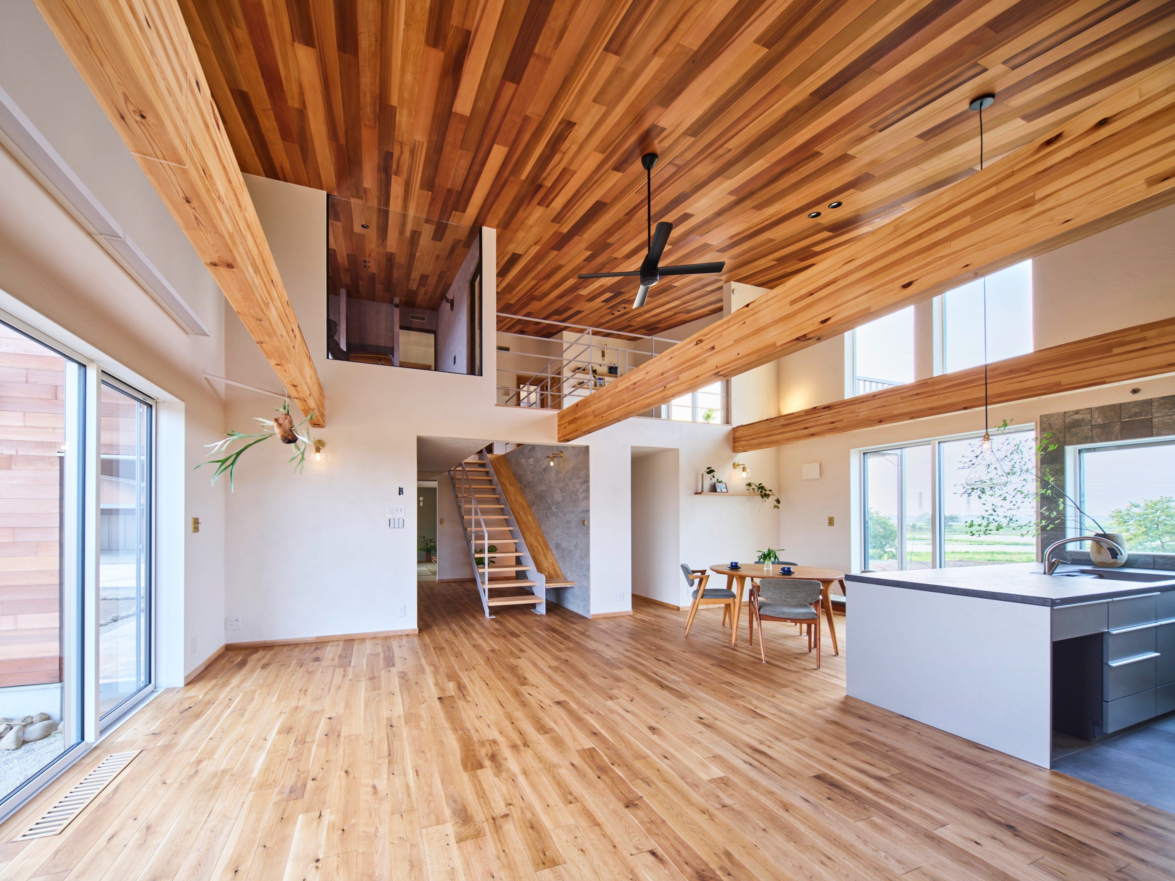 雄大な景色から受けるスケール感を室内に繋げるため大空間としたLDKは、 客間としても使える和室、一面ガラス張りにした書斎、ライブラリー兼プレイルームのホールと繋がっていて、どこにいても家族のつながりを感じられます。 壁になじむ鉄骨階段脇にはすべり台を造作するなど遊び心とこだわりが散りばめられています。