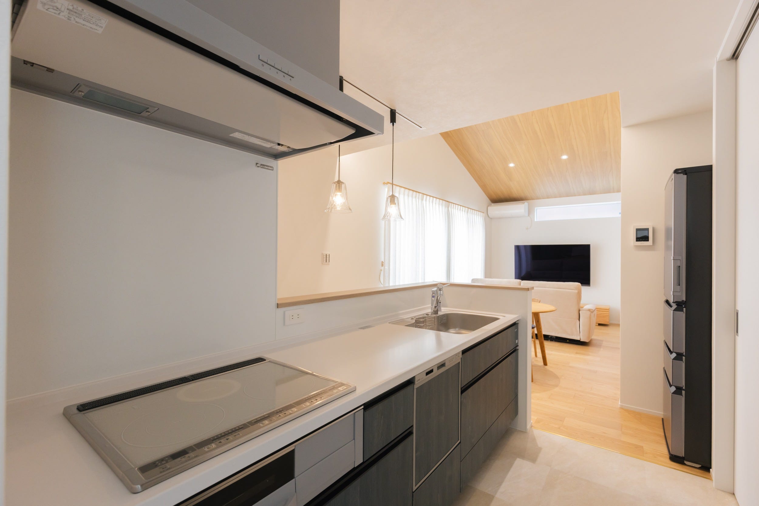 キッチンは使いやすさとサッと汚れも掃除できるタカラスタンダードのもの。キッチン周りの色味はグレーや黒系で抑えて落ち着いた印象に。キッチンバック収納は大きな引き違い扉の仕様にして片付けも楽々。